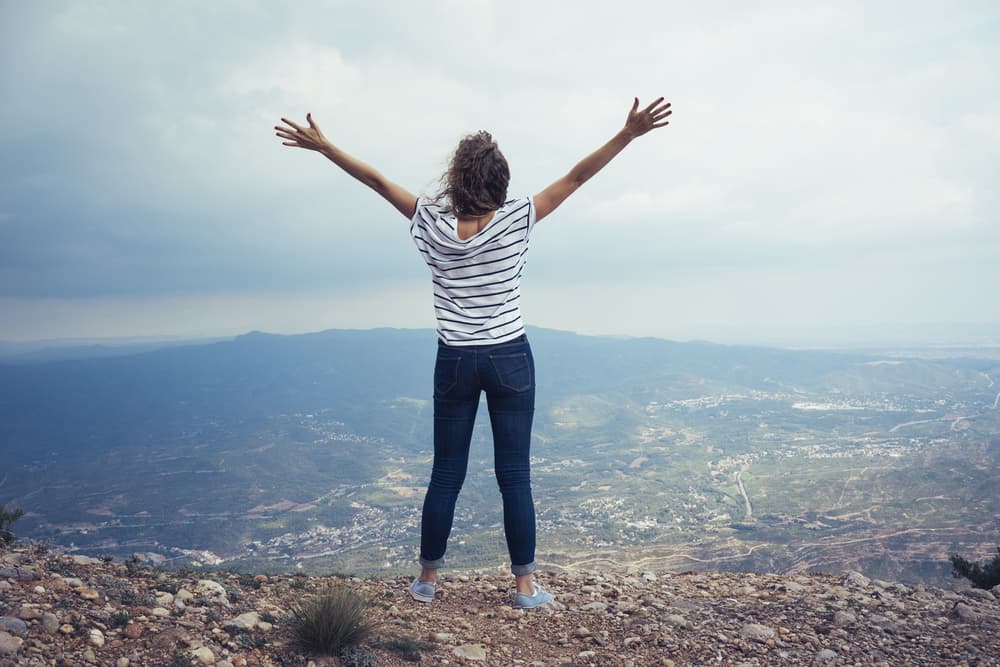 Woman on top of mountain